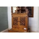A late 19th Century fretwork miniature chiffonier with pierced shelves and doors enclosing three