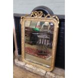 A 19th Century gilt wall mirror with gilded floral border and ribbon swag cresting