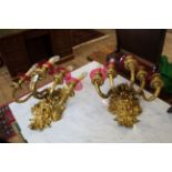 A pair of 19th Century cast brass five branch wall lights with satyr mask back plates and cranberry