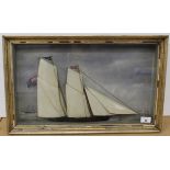 A 19th Century framed and glazed painted wooden half model of a ship in full sail against a painted
