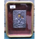 A small white metal covered religious icon housed in a glazed frame depicting the Madonna and Child,