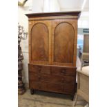A William IV mahogany four drawer linen press, with arched panelled doors and trays to interior,