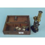 A vintage wooden cased brass students microscope (signs of age and wear)