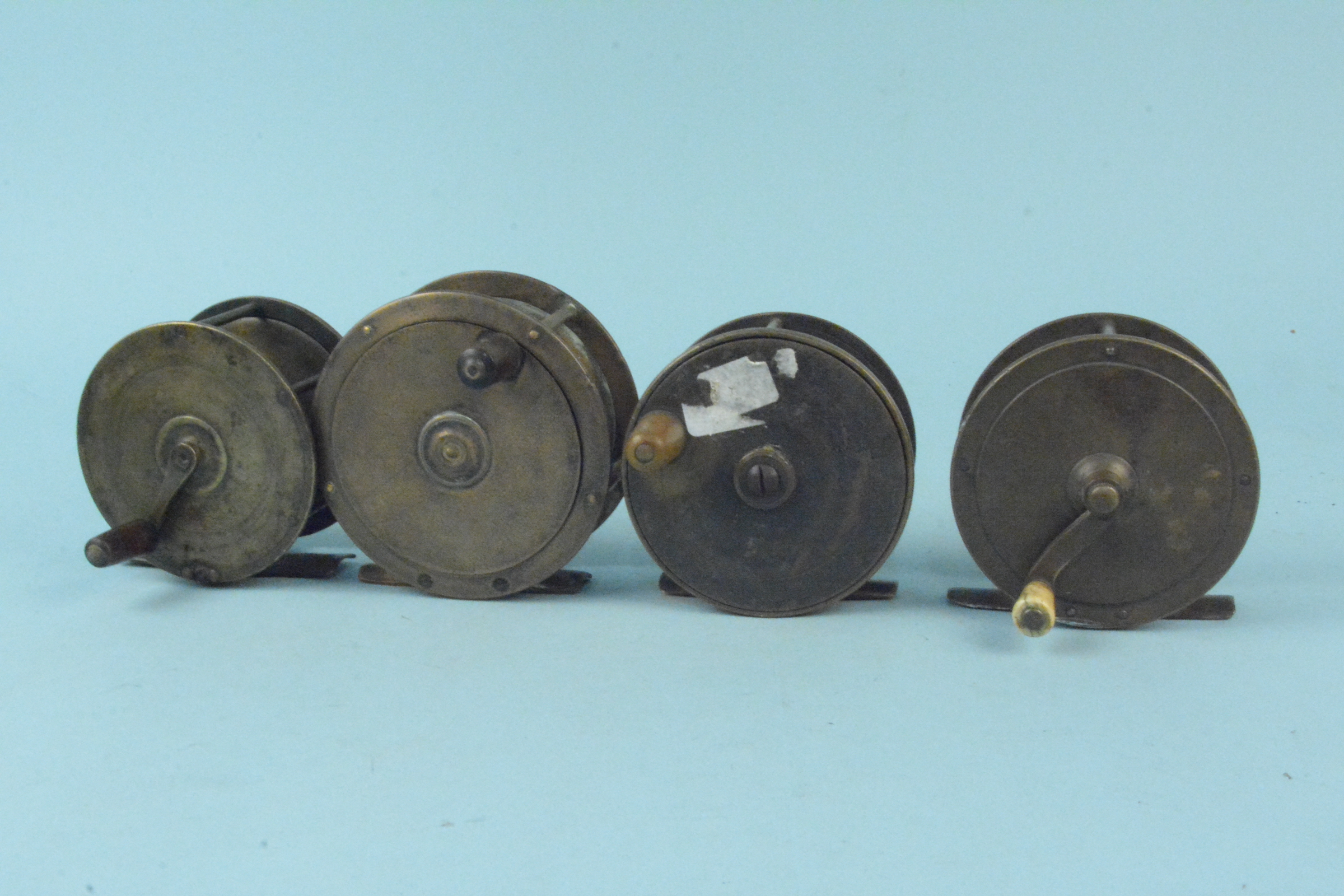 Four unnamed early brass plate wind reels
