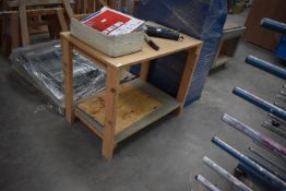*Wooden Worktable and a Blue Shelving Unit Containing Assorted Components