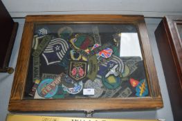 Two Small Tabletop Display Cases Containing Reproduction Military Cloth Badges