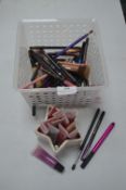Basket of Assorted Brushes, Pencils, and Lip Gloss
