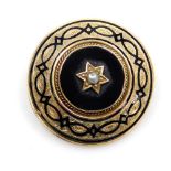 A Victorian circular black and enamel and seed pearl set mourning brooch, in yellow metal, with fol