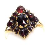 A late 19thC Continental garnet set ring, in an open work lozenge shape design, set in yellow metal,