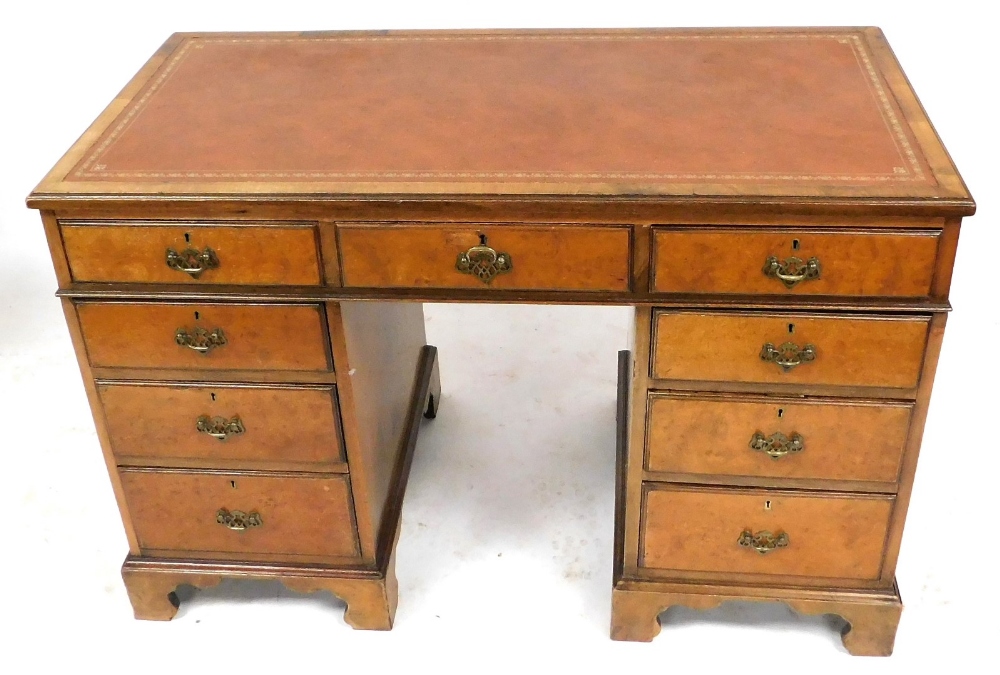 A mahogany twin pedestal desk, with a gilt tooled brown leather top, over one long and eight short d
