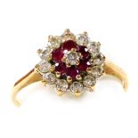 A 9ct gold, ruby and diamond flower head ring, in a concentric circular deign, basket set, diamonds