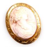 A 20thC pink coral cameo brooch, bust portrait of classical lady, in an oval yellow metal frame, fol