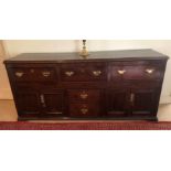 A George III oak dresser base, with moulded top, three drawers over two central drawers, flanked by