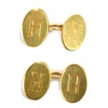 A pair of oval cufflinks, each inscribed H with three chain link, yellow metal stamped 18ct, 11g.