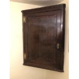 A George II oak hanging corner cupboard, with cross banded mahogany door with H brass hinges, 87cm h