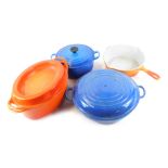 A group of Le Creuset, comprising a casserole dish and cover, paella pan and cover, casserole dish a