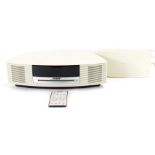 A Bose music wave system, in cream with remote and additional sound pack and instructions.
