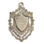 A silver shield fob, with pierced outer design and central shield stamped G Ward, inscribed West Thu