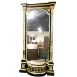 A Regency style gilt wood and ebonised floor standing pier glass mirror, the break front pediment ov