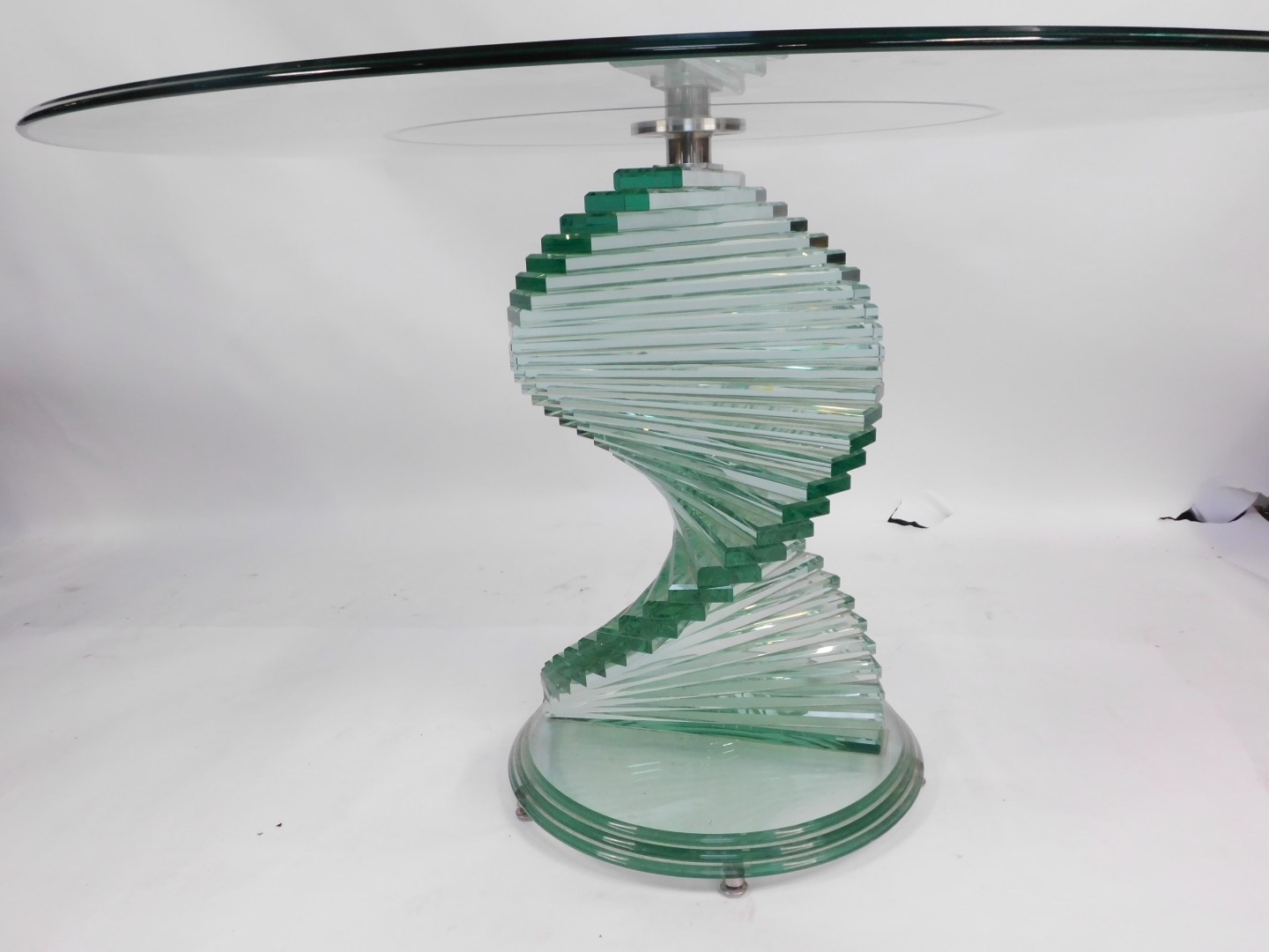 A modern cut glass coffee table, with a circular top, raised on a spiral staircase column over a ste - Image 2 of 2