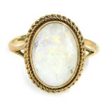 A 9ct gold opal dress ring, the oval opal in a rub over setting, with two row twist border, on V spl