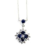 A 9ct white gold, sapphire and diamond pendant and chain, the pendant set with four sapphires surrou