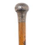 An early 20thC oak walking cane, with silver handle, hallmarks indistinct, 91cm high.