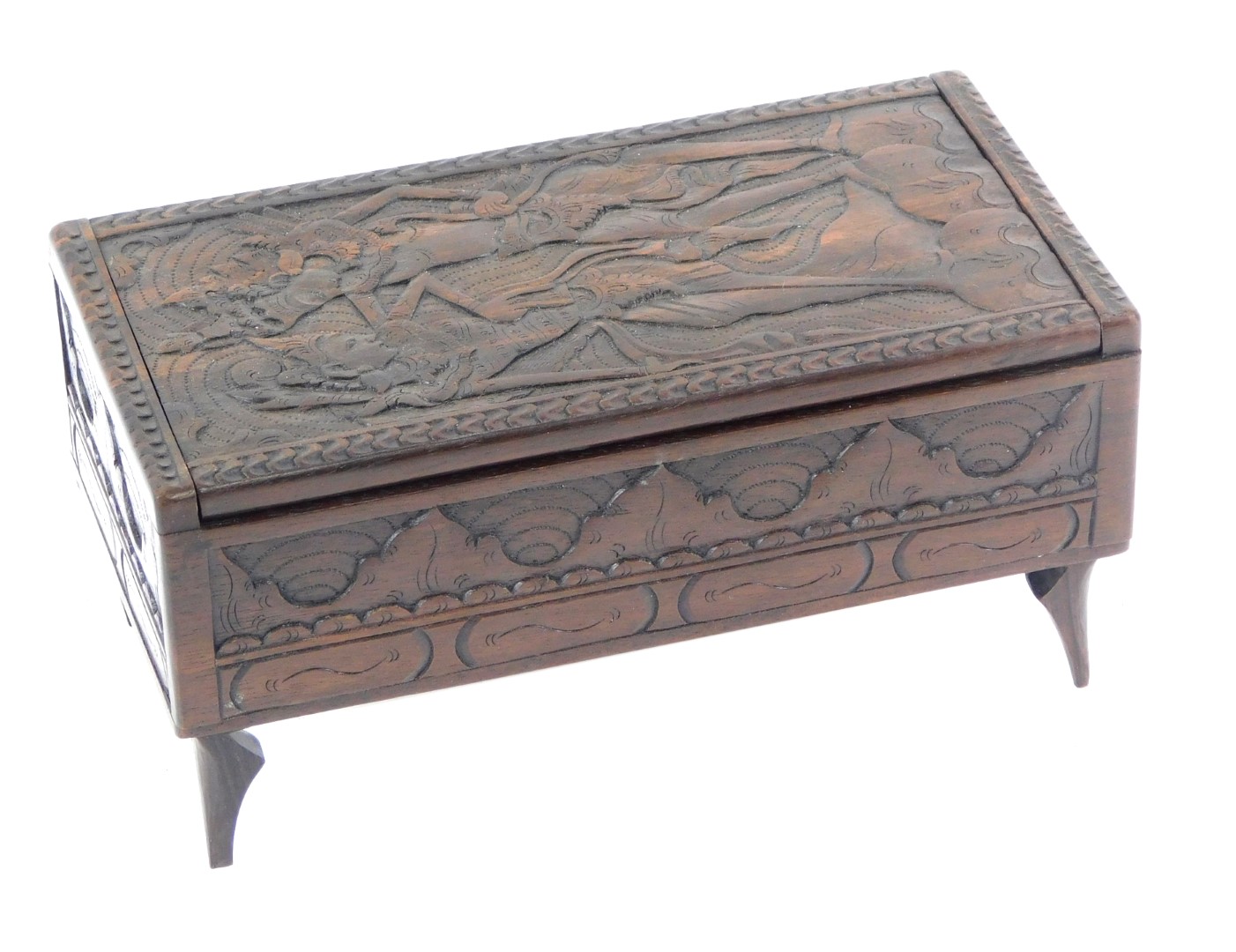 An Eastern carved wooden casket, decorated to the hinged lid with dancing figures, foliate carved fr