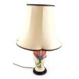 A Moorcroft pottery table lamp, decorated in the Magnolia pattern, against a cream ground, with matc