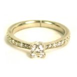 A diamond dress ring, with round brilliant cut in four claw setting, approx 0.25ct, with tiny diamon