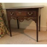 A George III oak lowboy, with over hanging rectangular two plank top, single frieze drawer with bras