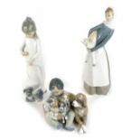 A Lladro porcelain figure group of a seated boy holding a clutch of puppies, a dog by his side, a fu