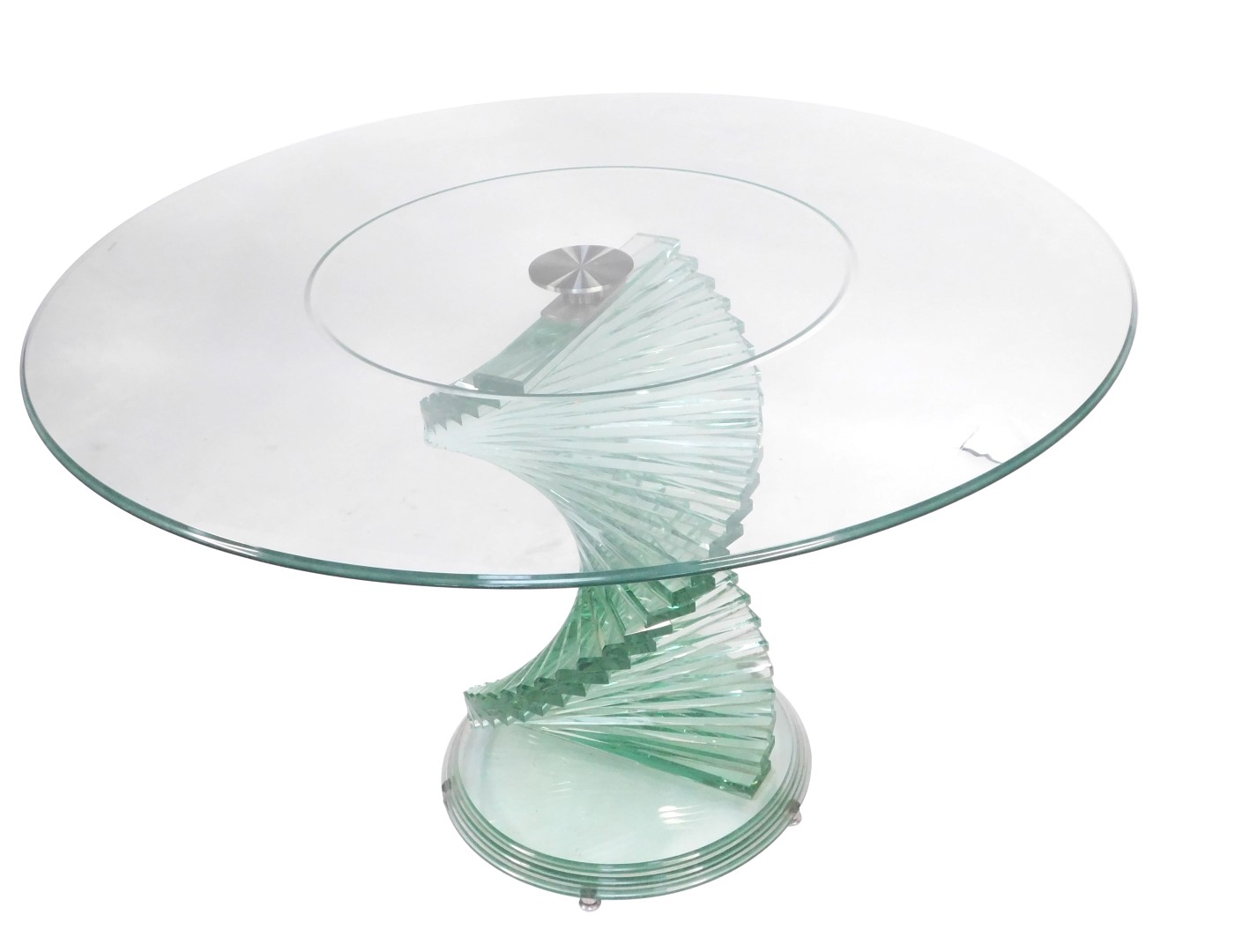A modern cut glass coffee table, with a circular top, raised on a spiral staircase column over a ste