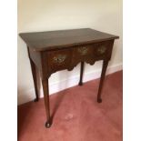 A George III oak lowboy, with over hanging top, three frieze drawers, taper turned legs with club fe