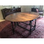 An early 18thC and later tipped gate leg table, with oval top, frieze drawer to each end, turned bal