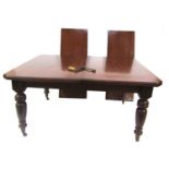 A Victorian mahogany wind out dining table, with one additional leaf, raised on turned legs, brass c