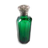 A late 19thC green glass scent bottle, with floral lid and plain T shaped stopper, 7cm high.