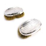 A pair of George V silver clothes brushes, by Mappin and Webb, with engine turned initialled backs,