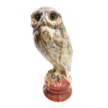A late 19thC French Emile Galle pottery figure of an owl, with green glass eyes, and mottled feather