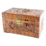 A heavily carved Chinese camphorwood box, profusely carved with figures, buildings and flowers, with