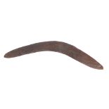 An early 20thC Australian boomerang, carved with a textured snake to both sides, 55cm long.