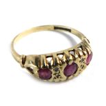 A 9ct gold gypsy ring, set with three rubies in rub over setting, with four tiny diamonds and scroll