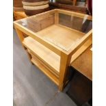 A pair of beech and glass two tier coffee tables, each of square form.