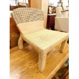 A deep seated wicker occasional chair.