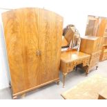 A 1950s walnut three piece bedroom suite, comprising compactum chest, mirror back dressing table and