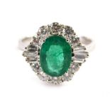 An 18ct white gold, emerald and diamond cluster ring, with an oval cut emerald approx. 1.79cts, surr