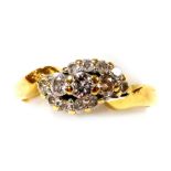 An 18ct gold and diamond ring, in a cross over style, size M, 3.4g.