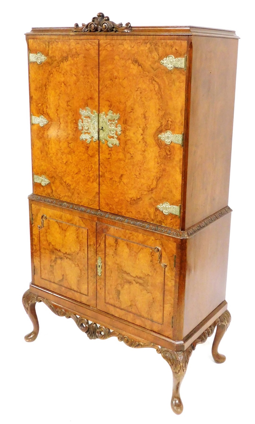 A reproduction walnut drinks cabinet, with carved crest to the top and fitted cabinet below enclosed