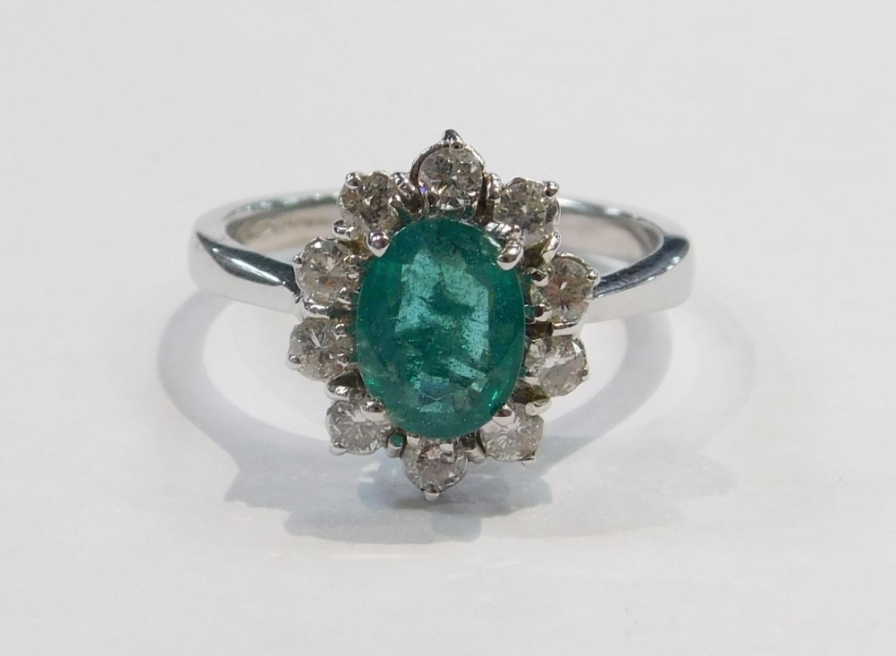 An 18ct white gold emerald and diamond ring, the oval cut emerald in a surround of brilliant cut dia - Image 2 of 4