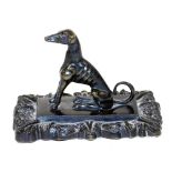 A Victorian bronze figure of a greyhound, modelled seated on a rectangular base within a floral surr